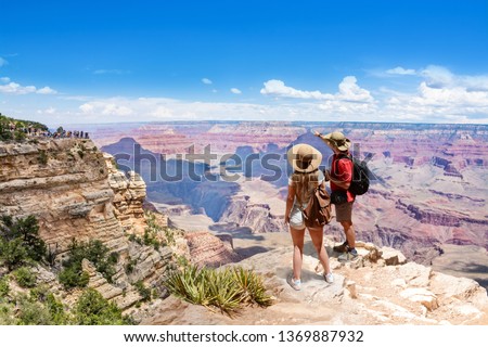 Couple on top of the mountain, looking at beautiful summer mountain  landscape. Friends on hiking trip enjoying view of Grand Canyon. South Rim. Travel in Grand Canyon National Park, Arizona, USA. Royalty-Free Stock Photo #1369887932
