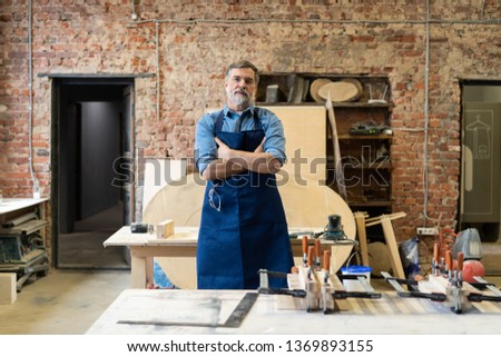 Mature handsome joiner work in carpentry. He is successful entrepreneur at his workplace Royalty-Free Stock Photo #1369893155