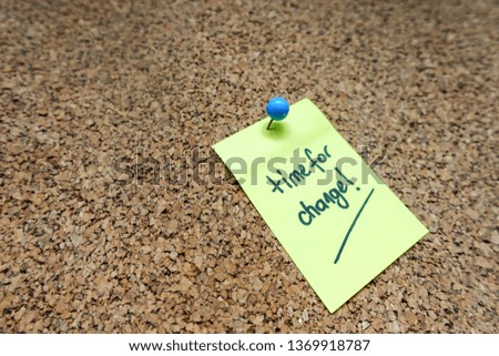 Yellow Sticky Note with Time For Change Message Pin on White Blue Push Pin On Cork board                               