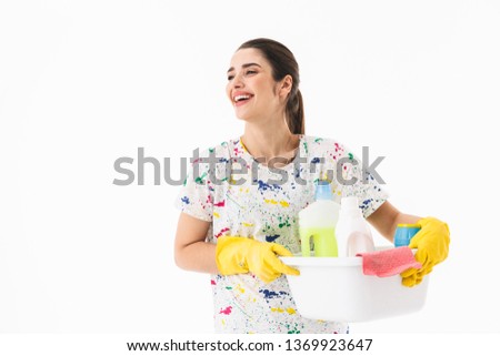 Photo of gorgeous housewife 20s wearing yellow rubber gloves for hands protection holding bucket with cleaning supplies isolated over white background