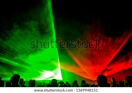 Colorful laser show in the club, outdoor with a lot of party people dance, club, dj