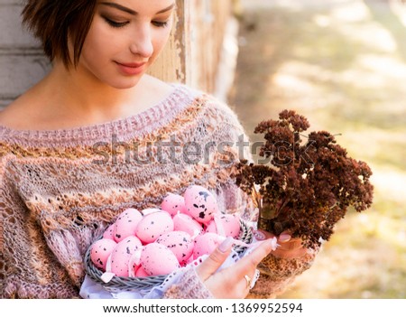 The easter mood, the girl poses with a basket of eggs in hands