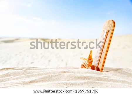 Summer photo of thermometer on sand 