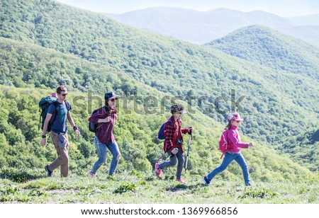 family with two kids have hiking  through the mountains