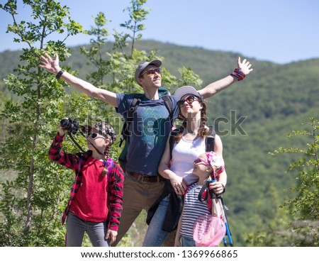 Family with two daughters travels along a beautiful path in the forest