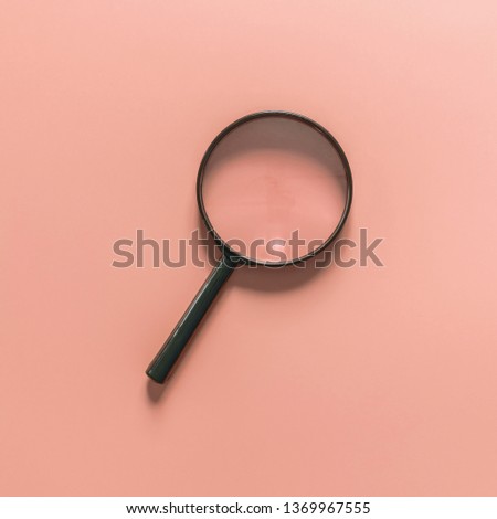 Black magnifying glass on a pink background. Minimal concept. Copy space for text Royalty-Free Stock Photo #1369967555