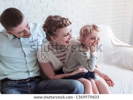 portrait of happy family sitting on sofa in living room