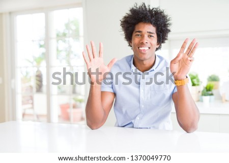African American business man showing and pointing up with fingers number eight while smiling confident and happy.