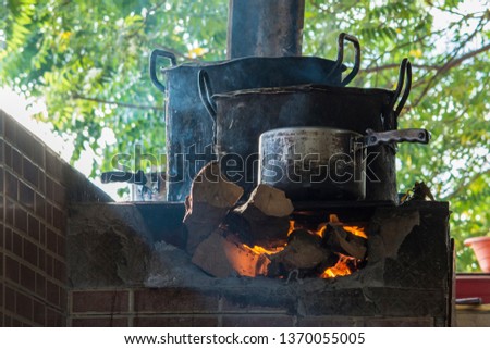 a dark pot on burning wood