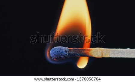 Macro shot of a wooden safety matchstick burning with a bright colorful flame. Royalty-Free Stock Photo #1370058704
