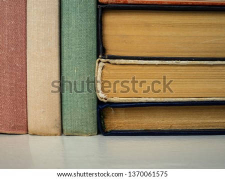 Heap of books of different flowers and forms. Books on the shelf in a home library. Old dusty books. Texture, background