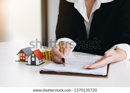 estate agent gives pen and documents agreement with customer to sign contract. 