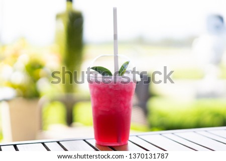 View of stawberry soda juice with green tea on top.