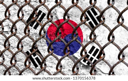 Immigration policy regarding migrants, illegal immigrants and refugees. Steel grid on the background of the flag of South Korea