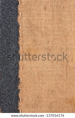 Poppy lying on sackcloth space for text