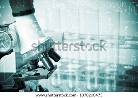 microscope and laboratory test tube on light blue background , science research equipment concept.