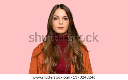 Young woman with coat portrait over isolated pink background