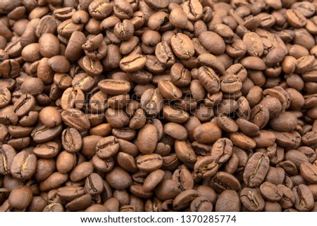 Coffee beans seamless background. Tiled texture of roasted scattered coffee beans. Design pattern. Top view.