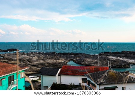 Picture of fishing village houses in the beach with horizontal line of the ocean.