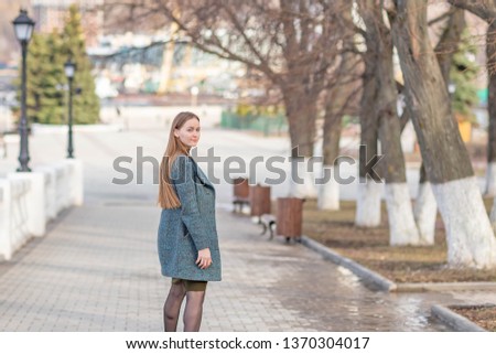 Girl in a coat in the alley on the Volga river in Cheboksary