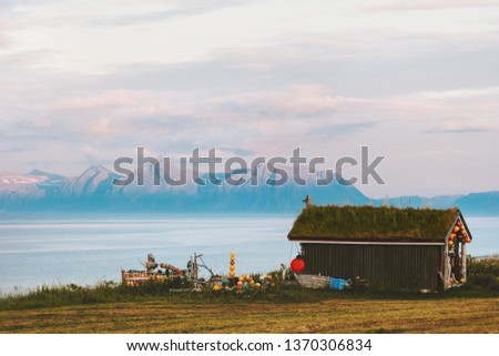 Norway landscape wooden house with grass roof on seaside and mountains sunset view 