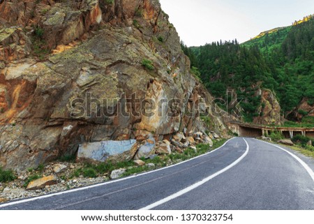 transfagarasan road at sunrise. popular travel destination of romania. beautiful summer landscape in mountains. road winding uphill through gorge with steep rocky cliffs