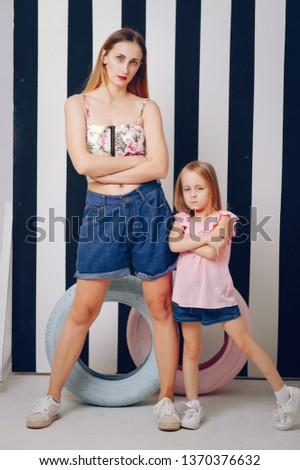 Stylish mother in a studio. Little girl in a fashion clothes.