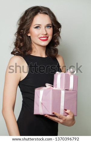 Happy woman holding gifts and smiling. Fashion portrait