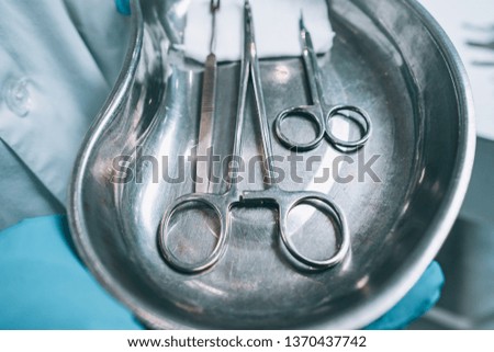 Several surgical instruments lie on a tray