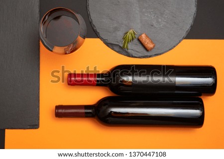 Geometry composition of wine cork on black slate board with glass of wine and bottle on colorful background