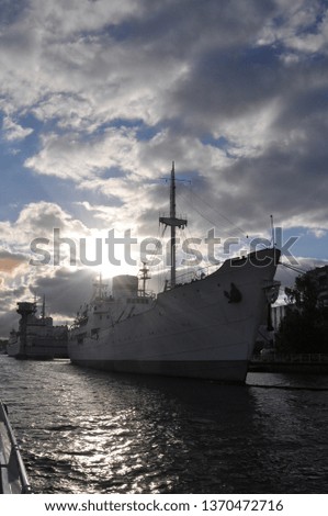 Large white modern ship on the water in the port of Kaliningrad lit by the setting sun