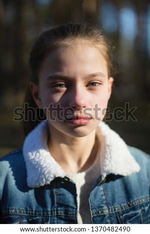 Closeup portrait of a twelve year old cute girl outdoors.