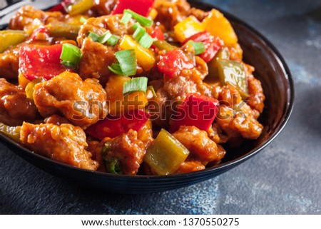 Sweet and sour chicken with colorful bell pepper on a plate. Chinese dish Royalty-Free Stock Photo #1370550275