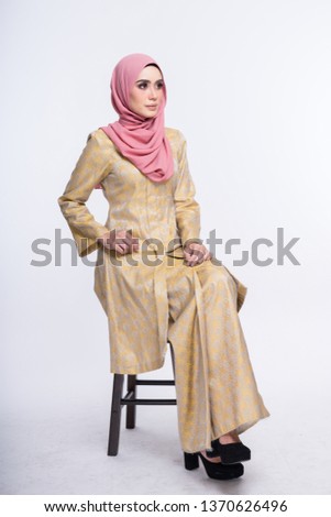 Beautiful female model wearing kebaya made from songket with hijab, an Asian traditional dress for Muslim woman isolated over white background. Eidul fitri fashion and beauty. 