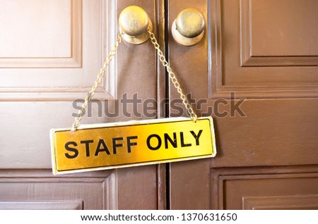 signs staff only  hang on the wooden door  .