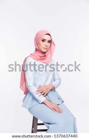 Beautiful female model wearing peplum dress with hijab, a modern lifestyle outfit  for Muslim woman isolated over white background. Eidul fitri fashion and beauty concept.
