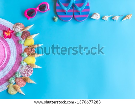 Summer  holiday  concept  setting  with  straw  hat,colorful  seashells,sunglassess  and  sandals  on  blue  background