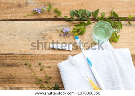 toothbrush ,toothpaste and mouthwash health care for oral cavity with terry cloth  ,purple flower arrangement flat lay style on background wooden