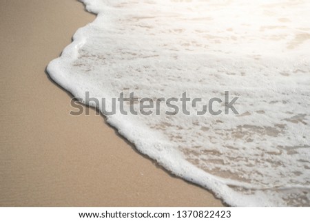 sea wave with bubbles on the sand beach 