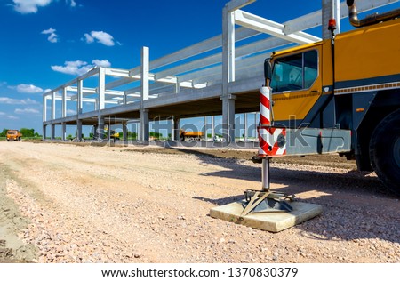 Extended side hydraulic outrigger to increase crane stability until is under heavy duty.  Royalty-Free Stock Photo #1370830379
