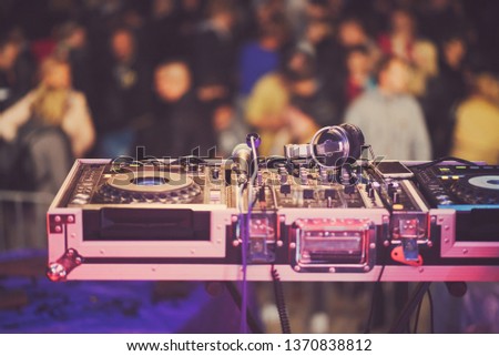 DJ Mixing Console with Microphone and Headphones on the Stage