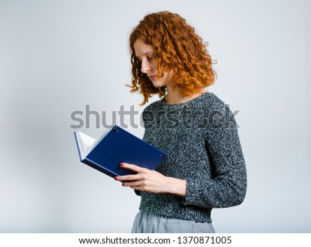 beautiful curly woman with diary isolated on gray background