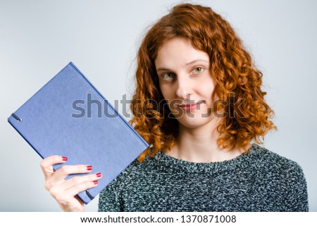 beautiful curly woman with diary isolated on gray background