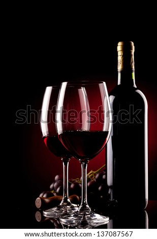 two glasses of wine, bottle, grapes and corkscrew