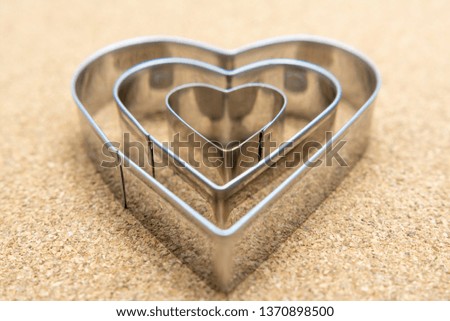 Heart, metal shape form with selective focus on pressed corkwood background. Conceptual photo