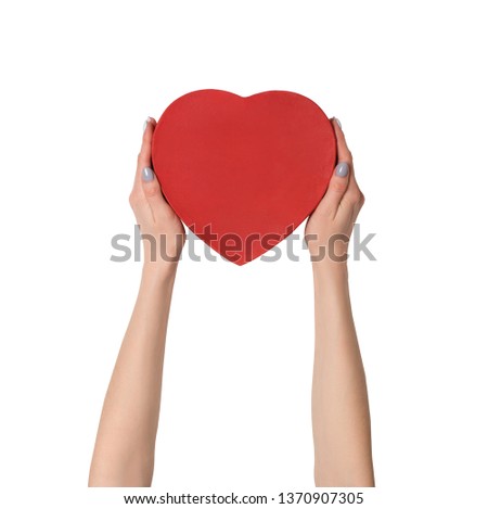 Female hand holding a red box in the shape of a heart. Isolate on white background.