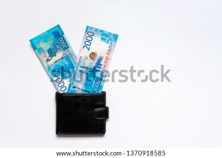 Victory symbol made of new russian money banknotes of two thousand roubles in leather purse on white background. Paper bills in pocketbook. Success in business, finance, wealth concept