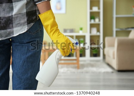 Woman with bottle of detergent in room
