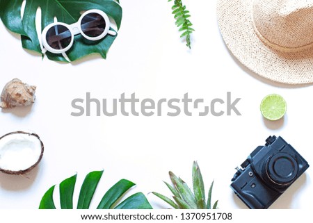 Summer travel tropical frame with a photo camera on the white background. Vacation concept flat lay. Top view. Copy space
