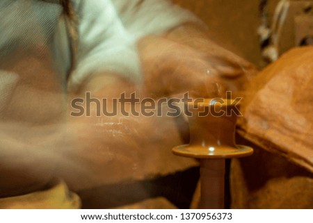 Craftsman artist making craft, pottery, sculptor from fresh wet clay on pottery wheel, long exposure